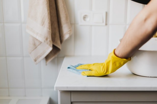 Cleaning supplies with yellow gloves and spray bottle